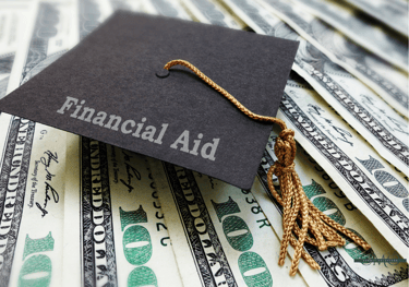 graduation cap labeled Financial Aid laying on $100 bills