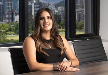 Retrato corporativo de joven mujer abogada con cabello rubio posando de forma profesional en una sala de reuniones