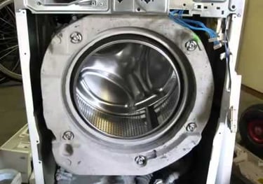 Front panel of a washer is removed for pump repair