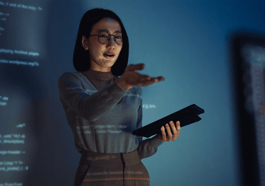 a woman in glasses and a gray sweater
