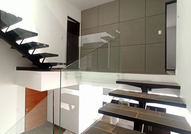 escalera panorámica que conecta los 3 niveles con barandal en cristal