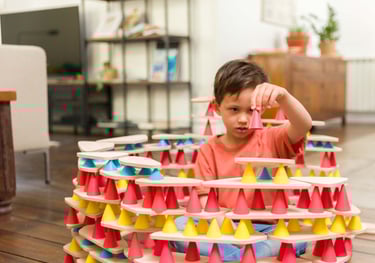 The child plays with silicone cones and wooden tables and creates the desired structure