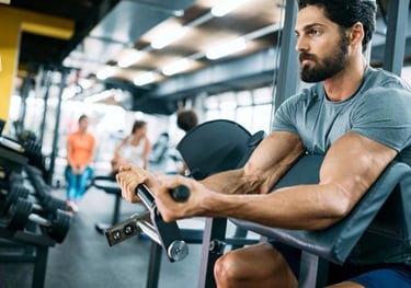 a man in a gym room with a barbell