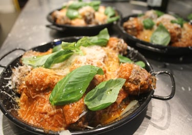 a pan of meatballs with basil sauce