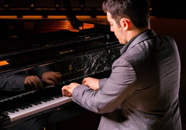 Stathis Chomatsas playing piano in a concert hall during a photoshoot