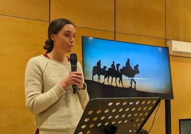 One of our church family preaching from the bible in front of a screen.