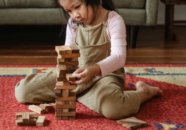 petite fille en train de construire une tour de cubes