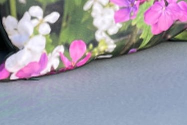 a pair of garden canvas cushions with floral and leafy designs on a sun lounger