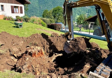 a bulldozer digging a hole in the grass