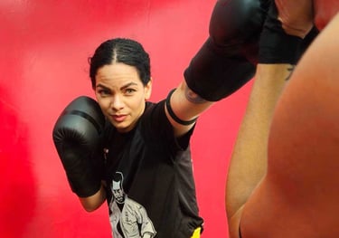 a woman in a boxing gloves is posing for a picture