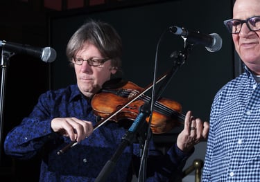 fiddler and singer performing with microphones