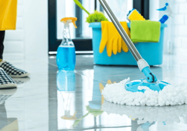 a person cleaning a floor with a mop