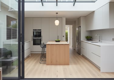 a kitchen with a large window and a table with a bowl of fruit