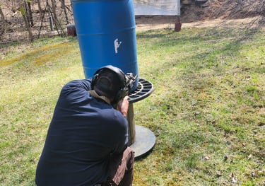 Man using Self-defense firearm (Carbine) kneeling from behind a barrier on training range.
