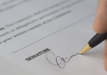 Person signing an application document, highlighting Admit 360's meticulous application review