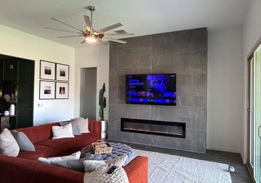 Living room with mounted TV and custom electric tile fireplace.