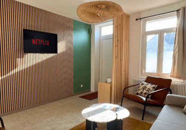 Salon avec TV connectée et Netflix inclus dans logement professionnel meublé.