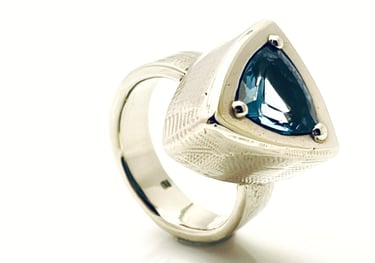 a ring with a blue TOPAZ and white GOLD