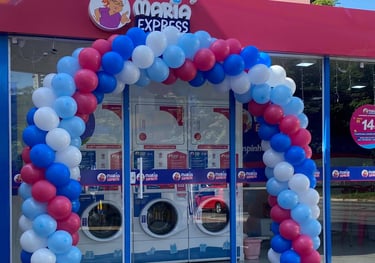 Arco de balões elegante em evento corporativo, destacando fachada da empresa.