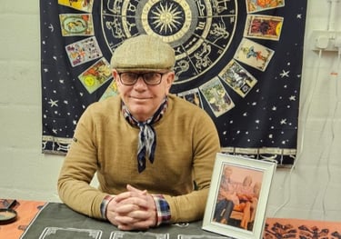 Rob hamilton 4th generation Romani reader, sitting down, astrological signs behind him