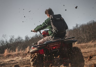Tourist riding ATV through muddy jungle trails and rice fields in Bali on an off-road adventure tour