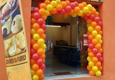 Arco de balões decorando entrada de loja em inauguração com cores personalizadas.