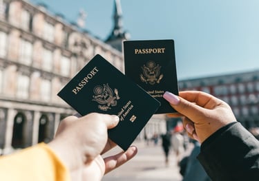 two people holding up two passports in front of a building Super Visa Insurance Quote TWC Financial