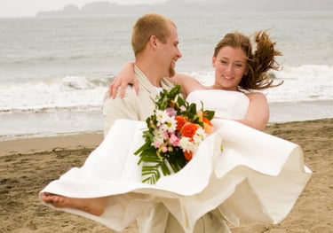 Groom spinning bride on Baker Beach in San Francisco