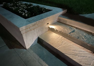 step light recessed in brick landscape planter box shining on a stone step
