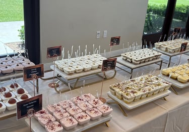 Indian Desert cups for a catering event laid out on a table. With gulab jamun, mousse, etc.