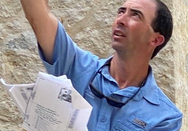 a man in a blue shirt is holding a cell phone designing lights on a house