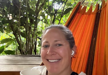 a woman in a hammock with a cup of coffee