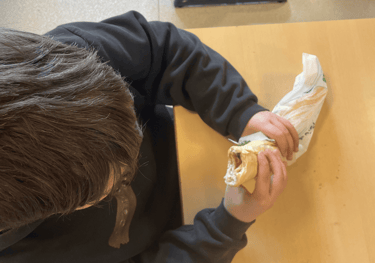 élève qui mange un sandwich