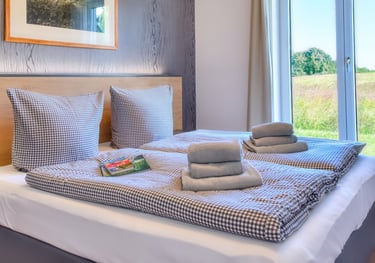 Schlafzimmer mit Doppelbett und Blick ins Grüne