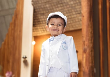 Foto profesional de bautizo de un niño joven en traje blanco de marinero