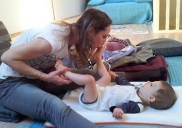 femme massant son bébé avec un bisou