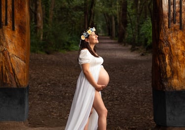 Fotografía profesional de maternidad embarazada con vestido blanco en un bosque encantado
