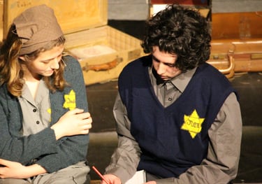 a man and woman sitting on a bench in a theatre