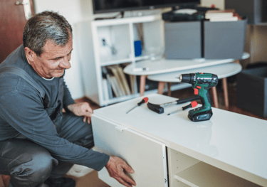 a man in a gray shirt is holding a drillet