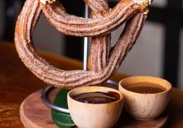 a huge churro pretzel hanging from a stand like a pretzel