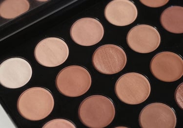 Overhead shot of a makeup palette with vibrant and nude tones in a North American / NYC Hispanic professional setting.