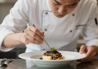 A chef in a professional uniform carefully garnishing a dish, showcasing bespoke service and culinary attention to detail.