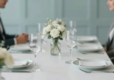 A table setup for a private business lunch with elegant glassware and subtle floral arrangements, incorporating the #AEC1B0 sage color.