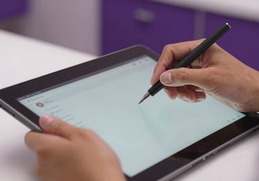 Close-up of a professional's hands in a Latin American beauty center using a high-end interface on a tablet. The setting is clean and premium with purple accents.