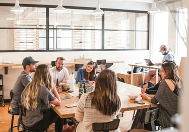 equipo joven dialogando en oficina alrededor de una mesa