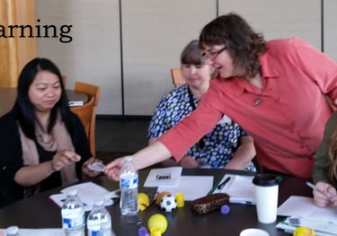 Facilitator working with adult learners at a round table.