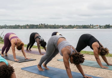group of black women doing yoga outside by water 