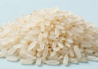 A high-quality studio shot of long-grain Basmati rice, showing clear texture and ivory white color against a clean, light blue background.