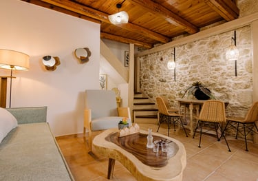 Rustic living room with stone wall, wood ceiling, and cozy seating area.