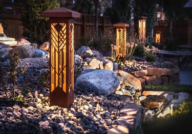 a garden with a wooden post and lights